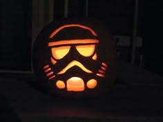 a star wars pumpkin carved to look like darth vader's helmet is lit up