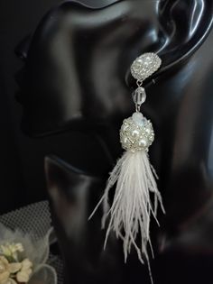 These beautiful earrings are made entirely by hand with beads and real ostrich feathers. The feathers are collected in a beautiful component created of pearls and beads. The pins are handmade with beadembroidery technique with beads and silver synthetic leather is applied from the back. The pin is connected to the tassel with a crystal bead. These earrings are quite long but are very light for the natural materials used. The white feathers and pearls give a very elegant and romantic look. These earrings are also perfect for your special day... a wedding or other important party. All jewels are delivered in a decorated box, ready to be given as a gift to your loved one. How to take care of your jewellery: put on your beauty products (cosmetics, perfumes, ...) before wearing your precious je White Feather Dangle Earrings, Elegant Adjustable Feather Earrings, Adjustable Feather Jewelry For Weddings, Elegant White Feather Earrings, Elegant Feather Earrings, Drop Earrings Wedding, Earrings Feather, White Feather, Ostrich Feather