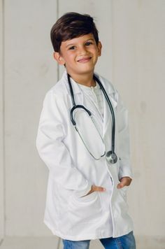 a young boy wearing a white coat with a stethoscope on his chest