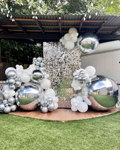 an outdoor area with balloons and silver balls