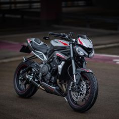 a silver and black motorcycle parked on top of a parking lot