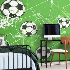 a bedroom with soccer balls painted on the wall next to a computer desk and chair