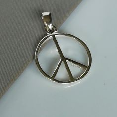 ▪︎ Sterling silver peace symbol charm. ▪︎ Can be used as a charm for necklaces, bracelets, key chains. ▪︎ This pendant is handmade with hypoallergenic sterling silver.Most of my pieces are marked with a 925 silver stamp. ▪︎ Size: 19 x 23 mm Weight: 1.48 gm ▪︎ Please note: This pendant comes without the chain, however, you can add a snake chain in the required length while making your selection. ▪︎ All jewelry arrives in a gift box. We can include a gift message from you if required. ▪︎▪︎ Please Symbolic Nickel Free Charm Necklace With Round Pendant, Symbolic Nickel-free Charm Necklace With Round Pendant, Symbolic Nickel-free Charm Necklaces With Round Pendant, Symbolic Silver Cadmium-free Charm Necklace, Hippie Style Nickel-free Pendant Jewelry, Hippie Silver Nickel-free Necklace, Symbolic Peace Sign Jewelry For Gift, Symbolic Silver Jewelry With Peace Sign, Peace Sign Jewelry For Gifts