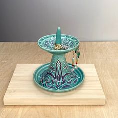 a blue candle holder sitting on top of a wooden table