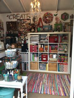 a room filled with lots of crafting supplies and crafts on shelves next to a white table