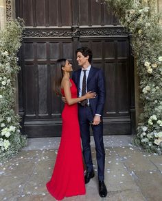 a man and woman standing in front of a wooden door