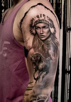 a man with a native american style tattoo on his arm and shoulder is standing next to a horse