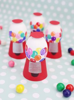 some gummy balls are sitting on top of the gumball machine holders that have been made to look like gumballs