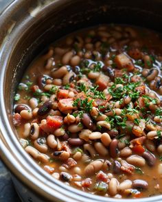 a pot filled with beans and vegetables on top of a table