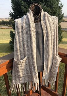 a white knitted shawl draped over a wooden deck