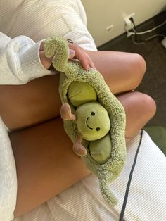 a woman holding two green stuffed animals in her arms, both wrapped around one another