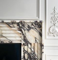 a marble fireplace surround in a white room