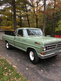 an old pick up truck parked in a driveway