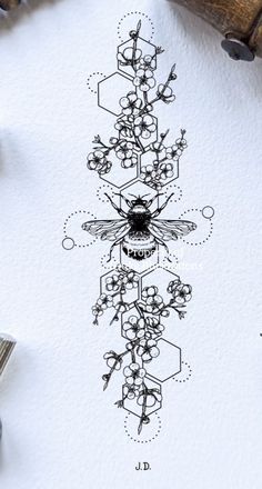 an ink drawing of a bee and flowers on white paper next to some other items