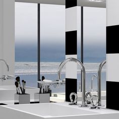 a bathroom with black and white walls, two sinks and large windows overlooking the ocean