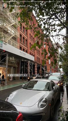 there is a silver car parked on the side of the street in front of some buildings