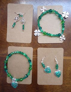 "Saint Patrick's Day Jewelry Sets Dangle Wire Earrings and Matching Bracelets 2 Styles: (1)  Shamrock Heart:   -Earrings:  Made with stainless steel ear wires. Hanging from the wire, on a head pin with an attractive 3 bead end,  are 3 green faceted glass beads.  On the bottom is a very pretty metal heart charm with shiny green enamel and a silver shamrock  surrounded by swirls.  The charm is one-sided.  Earrings  measure a total of 1.25\" from the top bead to the bottom of the  heart charm.  The charm itself is 3/4\" L x 1/2 \" wide.   -Bracelet:  Made using a clear stretch cord, it is beaded with a  variety of green glass beads.  The drop is made from the same  charms as the earrings, except this charm is double-sided.   The bracelet is 8\" around unstretched, and can be stretched easily Handmade Green Jewelry For Valentine's Day, Green Nickel-free Jewelry For Mother's Day, Valentine's Day Jewelry With Matching Adjustable Earrings, Adjustable Green Jewelry For Valentine's Day, Metal Dangle Earrings For May Birthstone, Dangle Metal Jewelry For May Birthstone, May Birthstone Dangle Metal Jewelry, Adjustable Green Jewelry For Mother's Day, St Patricks Day Jewelry Diy