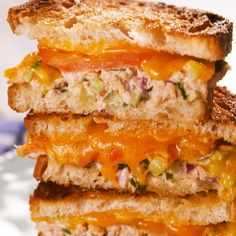 three grilled sandwiches stacked on top of each other with cheese and meat toppings