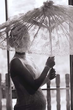 a woman holding an umbrella in front of a window