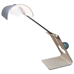 a desk lamp that is on top of a metal stand with a blue ball underneath it