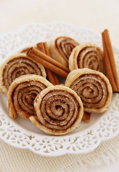 cinnamon rolls on a plate with cinnamon sticks