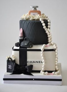 a chanel cake with pearls and purses on top, all decorated in black and white