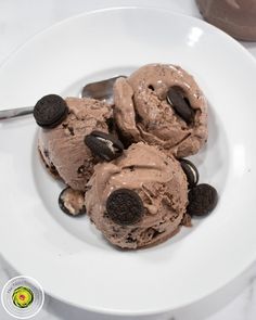 three scoops of ice cream on a plate with chocolate chips and oreo cookies