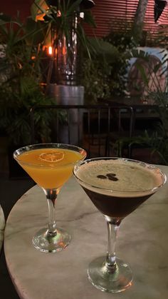 two martinis sitting on top of a table next to each other