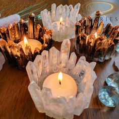 some candles are sitting on a table next to crystals