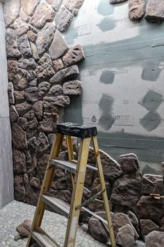 a ladder leaning against a rock wall in front of a stone wall that has been built into it