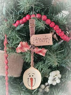 a christmas ornament hanging from the top of a tree with berries on it