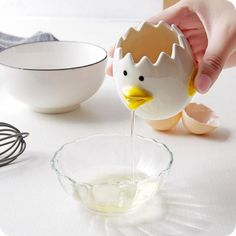 an egg being poured into a glass bowl