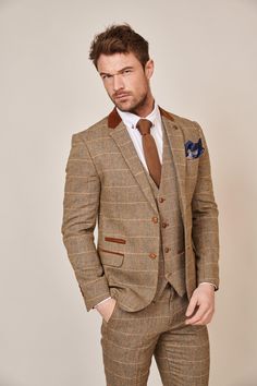 Inspired by old age country wear, the DX7 suit remains an ever so popular style. Reminiscent of the 18th century, it is ideal for Autumn/Winter with its earthy colour palette and heavy fabric. A touch of modernism is added with a velvet contrast collar, elbow pads and pocket trims, nudging it back into the 21st century. Check our more of Jonny's looks here. Features Herringbone Slim fit Single-breasted Notch lapel Double back vent Four button cuff Double button blazer fastening Complimentary nav Winter Beige Suit For Tailoring, Classic Brown Outerwear For Wedding, Fitted Brown Tweed Three-piece Suit, Classic Brown Wedding Outerwear, Bespoke Fall Suits, Brown Winter Wedding Outerwear, Winter Wedding Brown Outerwear, Tailored Brown Tweed Suits, Brown Three-piece Suit With Suit Collar For Fall