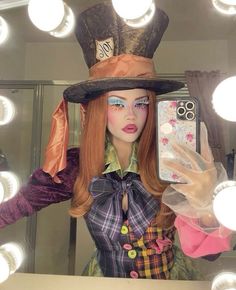 a mannequin wearing a top hat and holding a cell phone in front of a mirror