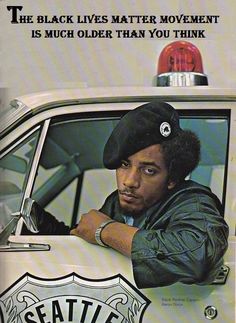 a man sitting in the driver's seat of a police car with his arms crossed