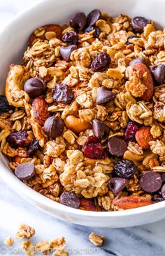 a bowl filled with granola, nuts and raisins