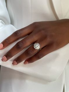 a close up of a person wearing a ring on their finger and holding onto a white shirt