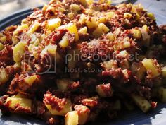 a blue plate topped with potatoes and meat