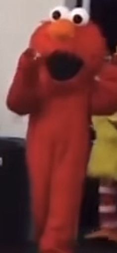 a man in an orange sesame character costume