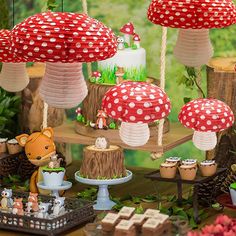 a table topped with lots of cupcakes and cakes covered in red polka dots