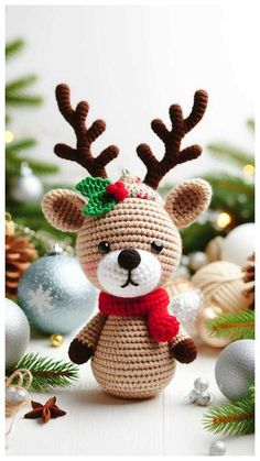 a crocheted reindeer with a green bow on it's head sitting in front of christmas decorations