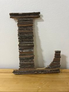 a tall wooden letter sitting on top of a wooden table