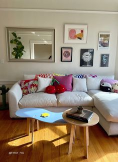 a living room filled with lots of furniture and pictures on the wall above it's coffee table