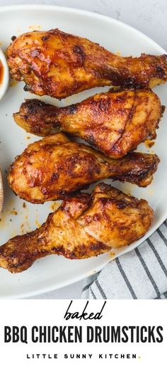 baked bbq chicken drumsticks on a white plate with dipping sauce in the background