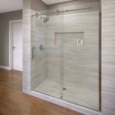 a bathroom with a glass shower door and wood flooring on the side of the room