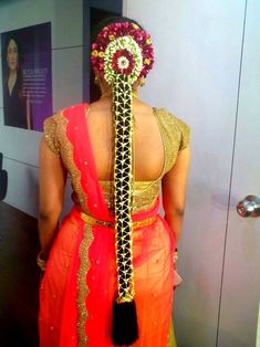 the back of a woman's sari with an elaborate headpiece on her head