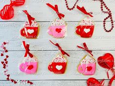 valentine's day cookies and decorations on a white wooden table with red stringing