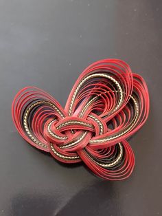 red and gold leather bracelets on a black surface with one knot in the middle