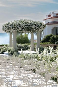 an outdoor wedding setup with white flowers and greenery