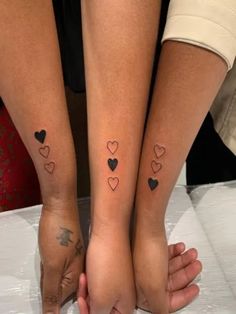 two people with matching tattoos on their legs, one is holding the other's hand